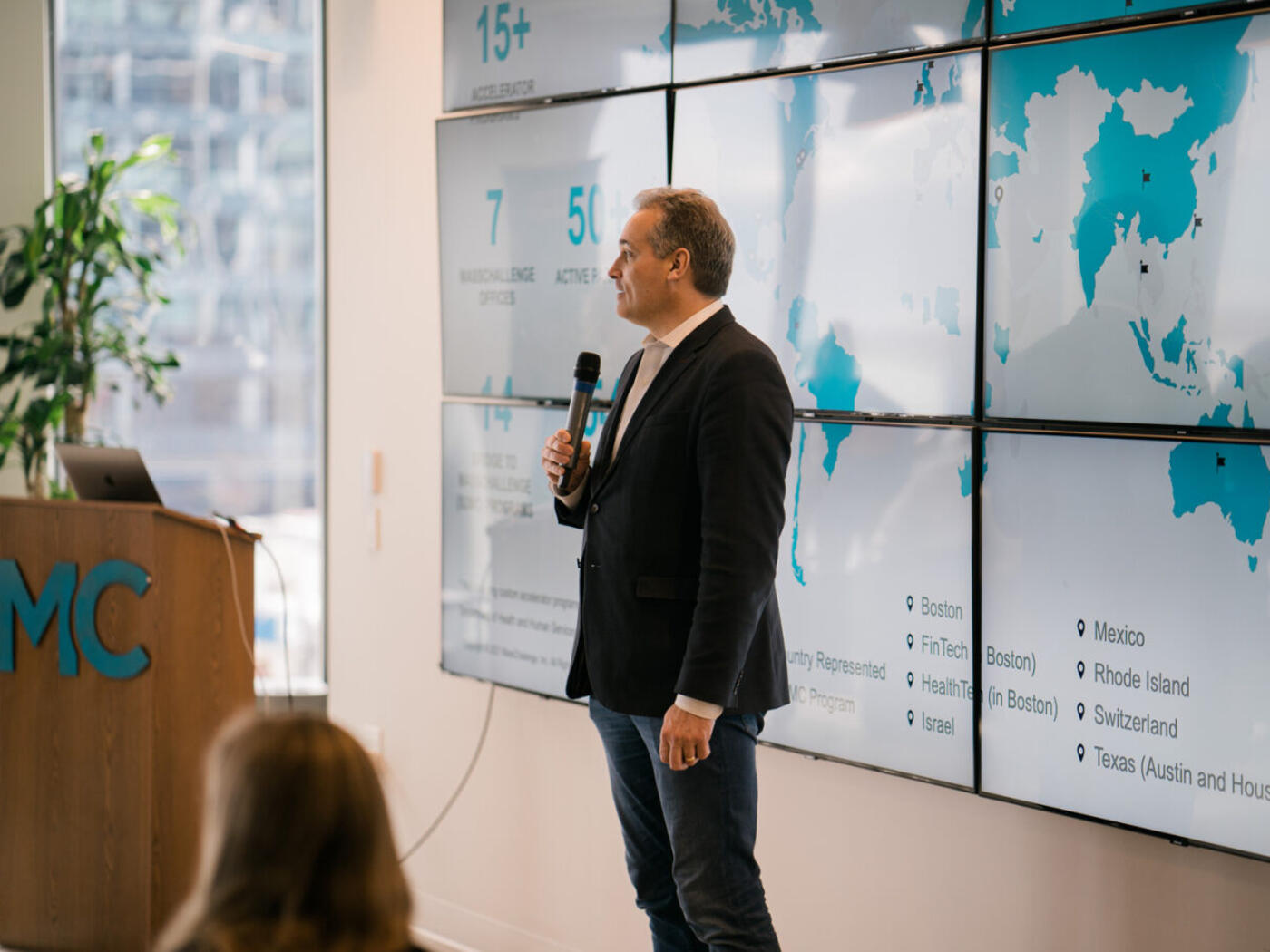 Phil Budden speaking in front of a world map on the wall