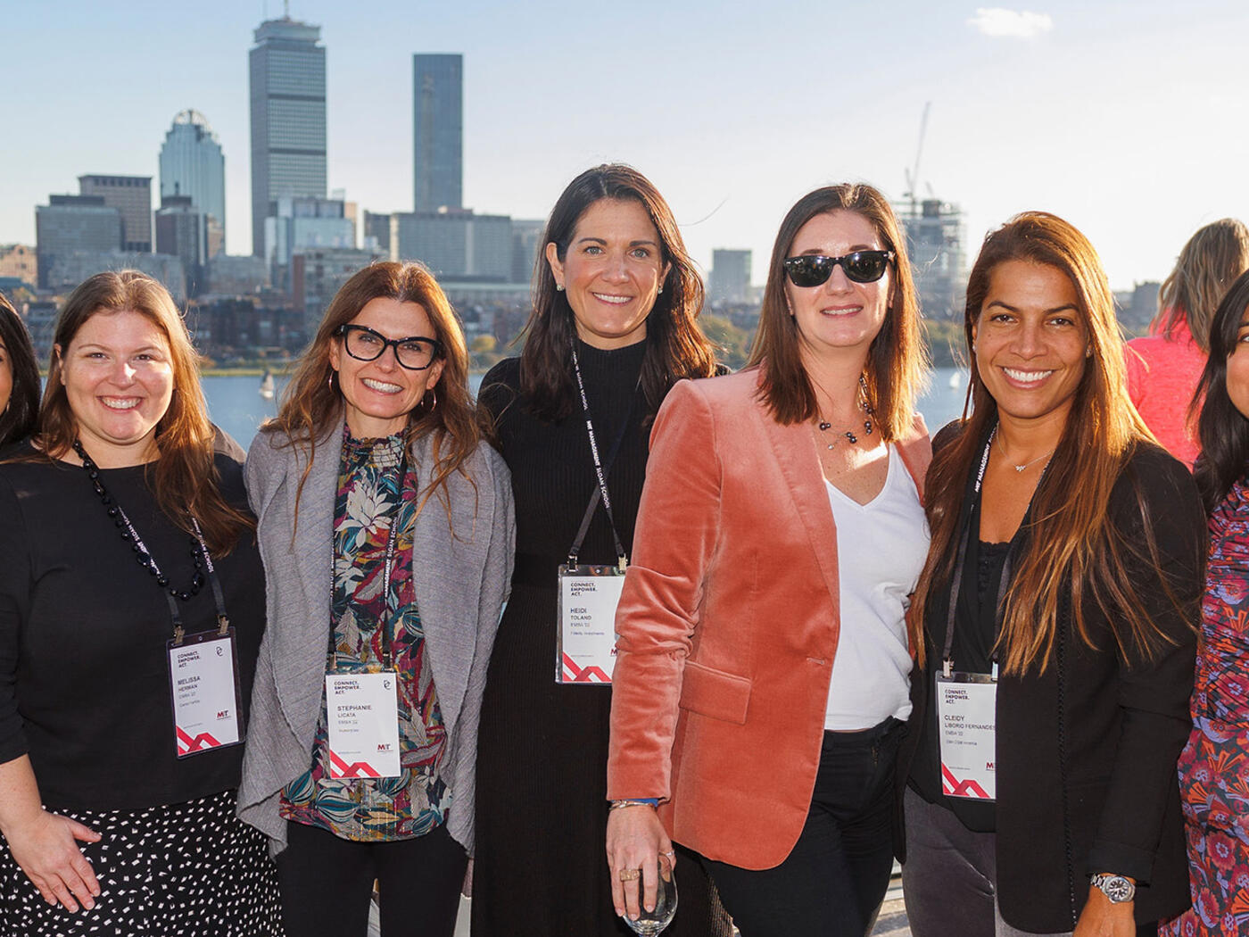 Group of women pose for photo in front of Boston skyline