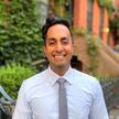 Headshot of Aneesh Kanakamedala outside, greenery behind him