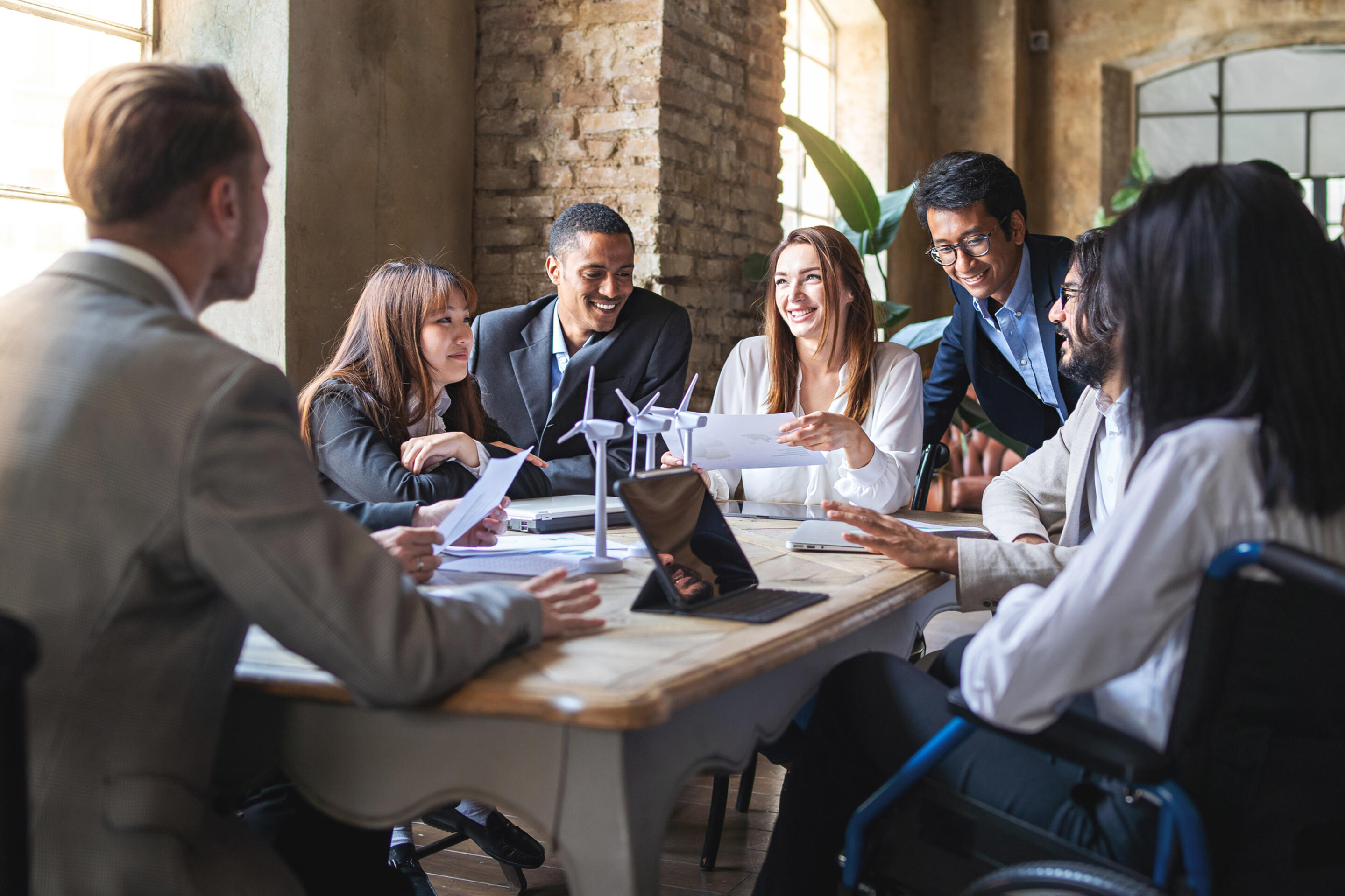 Group of people in corporate dress at a table, having a meeting